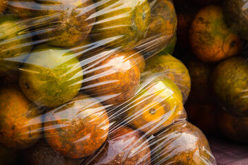A bunch of oranges are in plastic bags