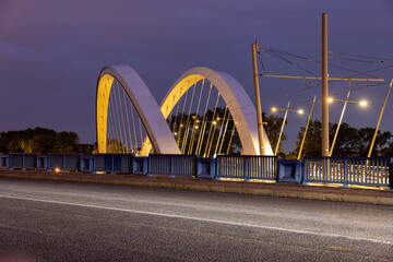 Fototapeta premium illuminated tram stop with a bridge in Lyon at night