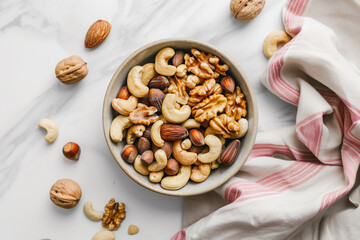 A bowl of mixed nuts placed on an empty table with a white background and striped napkin