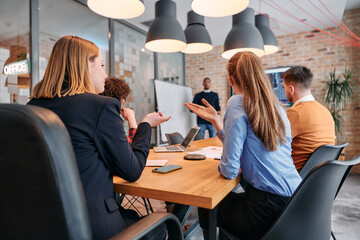 African-American businessman leads a meeting, passionately presenting a business plan to his attentive team, fostering collaboration and strategic thinking