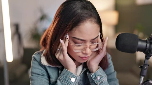 Woman, headache and microphone in recording studio for podcast, production and streaming. Content creator, media and stress or tension for editing, overtime and project for platform in creative space