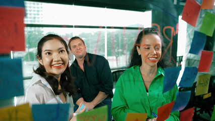 Portrait of professional diverse business team brainstorming marketing idea on colorful sticky...