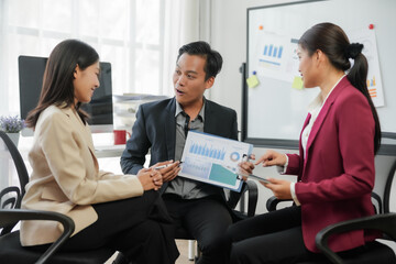 Business team discussing financial strategy with graphs and charts in modern office setting.