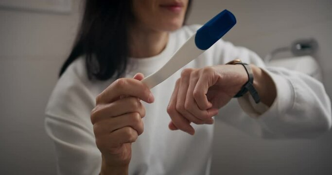 Close-up of pregnancy test in woman hands. Pregnancy concept, family planning. Woman using pregnancy home test, female expecting kid