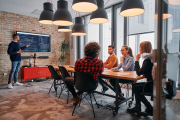 African-American businessman leads a meeting, passionately presenting a business plan to his attentive team, fostering collaboration and strategic thinking