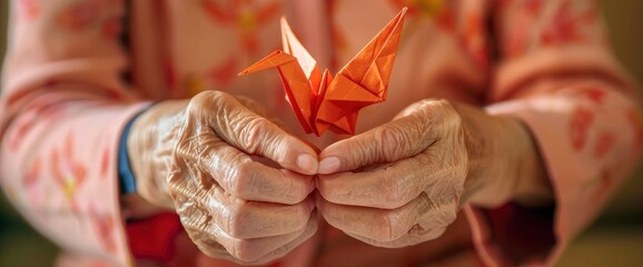 Fototapeta premium The Hands Of An Elderly Woman Folding Origami Paper, Creating An Origami Crane, Symbolizing Peace And Creativity,High Resolution, Ultra HD