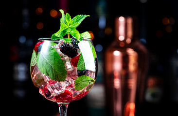 Summer refreshing alcoholic cocktail drink with berries, gin, vodka, soda, mint and ice, black...
