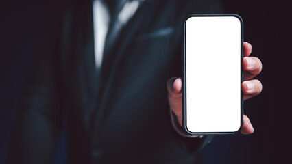 A businessman holds a cell phone in his hand with a blank screen for inserting pictures or text.