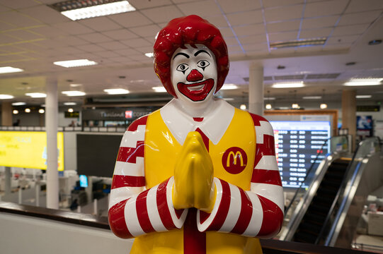 CHIANG MAI, THAILAND - OCTOBER 26, 2023: life-size Ronald McDonald statue greeting customers with the traditional Thai greeting wai at McDonald's restaurant in Chiang Mai International Airport.
