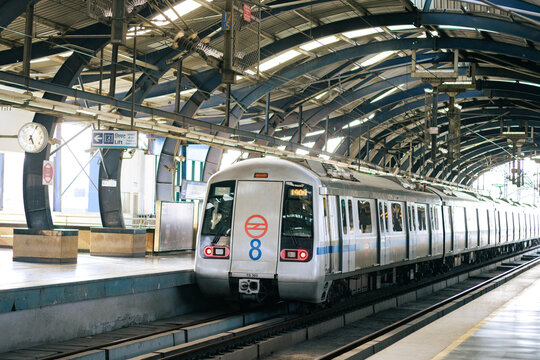 Delhi metro and the metro station. Metro rail in delhi. Dmrc metro entering the station.