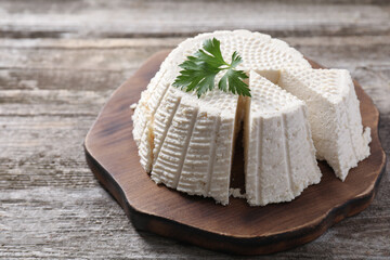 Tasty ricotta (cream cheese) on wooden table, closeup