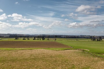 Agricultural landscape with clouds and grassland pasture