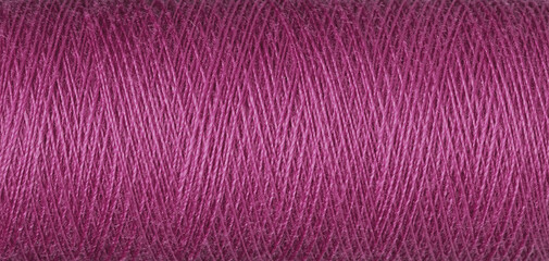 macro texture of a skein of pink sewing thread