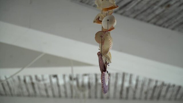 Hanging ornament made of seashells, hanging from the ceiling of a house.