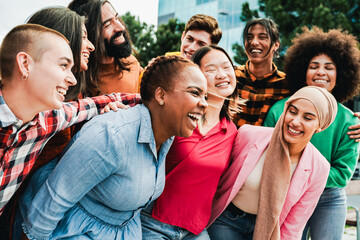 Diverse group of friends having fun in city in summer day. Young people celebrate holiday vacations outside