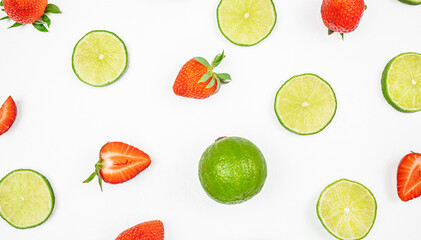 citrus fruit lime and sliced strawberries on white background. Colorful pattern