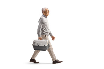 Elderly man carrying a pet carrier and walking