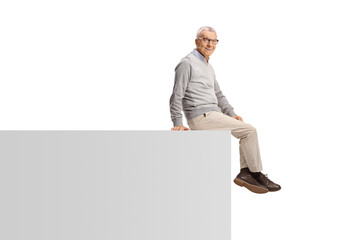 Elderly man sitting on a wall