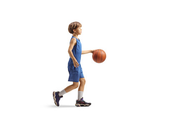 Full length profile of a boy walking with a basketball