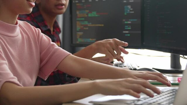 Slow motion back end software developer engineer for computer programming working together on debugging writing computing code, solving complex algorithms display on monitor in office. Burgeoning