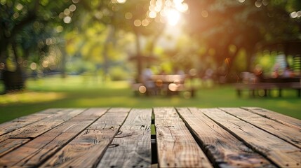 Empty wooden table and blurred view of friends cooking food on barbecue grill in park