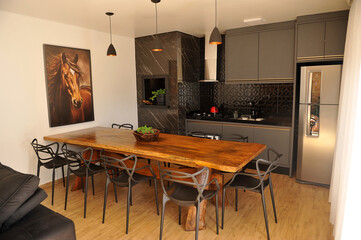 interior de cozinha preta com mesa rustica de madeira 