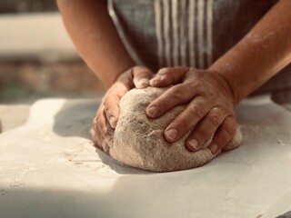 Woman baker kneading the dough.
