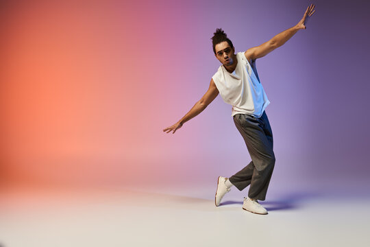 A young African American man dances with style against a vibrant gradient backdrop.