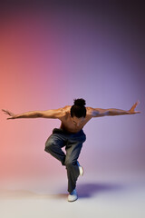 A young African American man dances on a colorful gradient background.