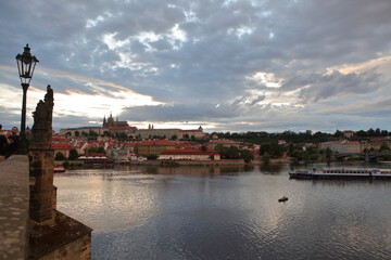 Obraz premium view of prague in czech republic from charles river with reflection on river and clouds. 
