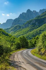 Fototapeta premium Country road through lush forest, mountains backdrop Sunny day, inviting exploration nature's beauty