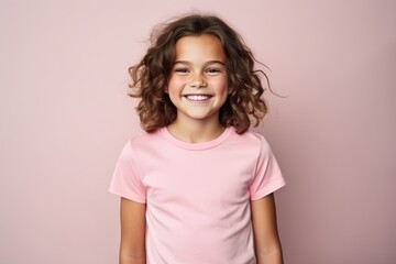 Portrait of a smiling little girl with curly hair over pink background