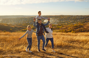 Happy family walking on golden field at sunset father mother son and daughter. Happy family serene ambiance deep connection admire tranquil beauty of expansive yellow meadow Happy family walking