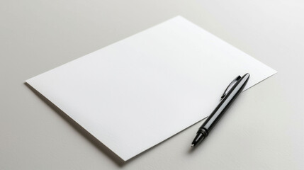 A blank piece of paper with a pen lies on a white surface, ready for writing or drawing.