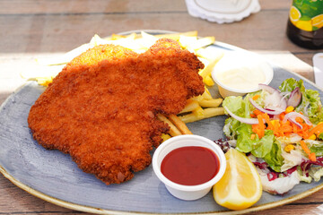 German Wiener schnitzel  ( Schnitzel mit Pommes Frites ) at beer hall in Germany 