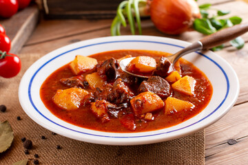 Beef goulash, soup and a stew, made of beef steak, potatoes and plenty of paprika. Hungarian traditional meal, typical Czech food