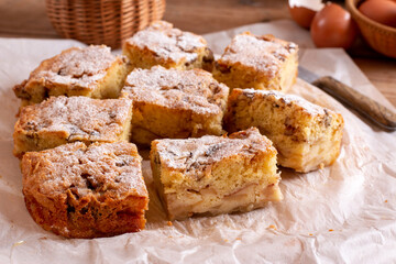 Traditional apple pie on a white plate on a wooden table. Charlotte pie on a platter. Delicious homemade pastry on the table.