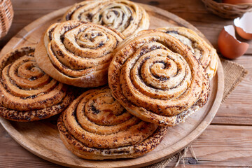 Fototapeta premium Poppy seed rolls and cardamom buns, Traditional Nordic baked sweet breads on board. Homemade bakery concept for background and wallpaper.