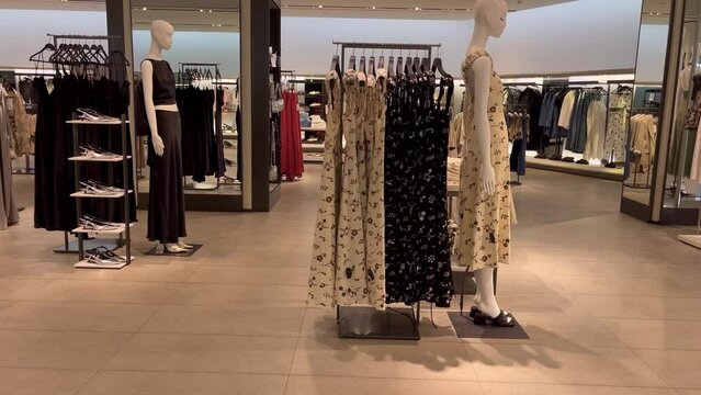 Shopping mall boutique filled with fashion tailoring, multiple racks with fashionable formal wear. Empty clothing showroom with trendy shirts on hangers, small business concept. Buying clothes. High