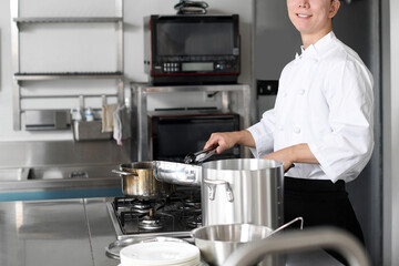 加熱調理をする若いアジア人の男性調理師