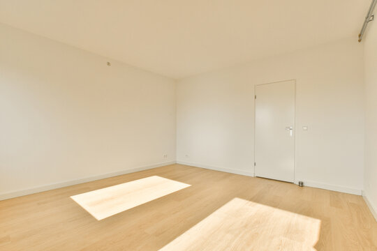 Spacious and well-lit empty room with wooden flooring