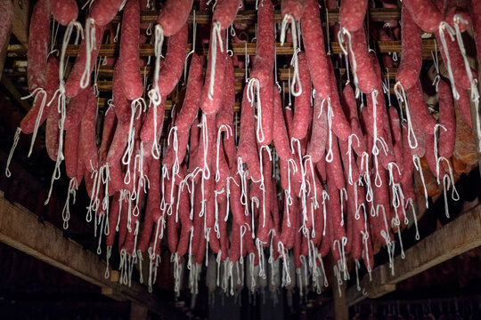 Rows of traditional Sobrasada sausages hanging in a curing room
