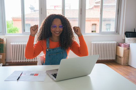 Young professional woman celebrating success at her workspace