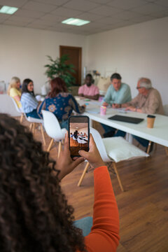 Diverse team in a business meeting captured on smartphone