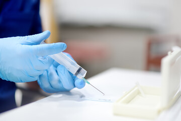 Oncologist performing a cancer biopsy test during the appointment of patient. The doctor applies a...