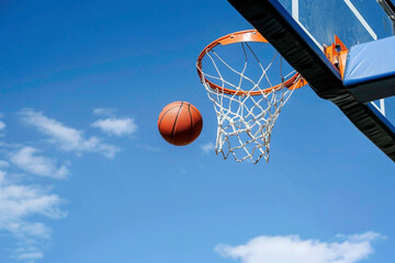 Basketball approaching the hoop scoring net in competition. Sports, practice, and determination, teamwork, achieving the success and setting goals concept