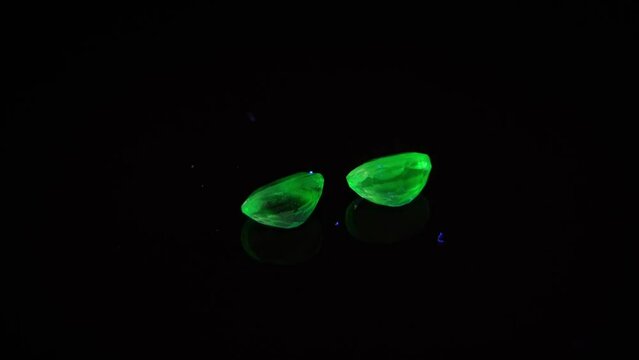 natural green opal hyalite under uv light on the black background