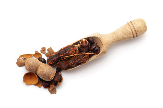 Top view of a wooden scoop filled with Fresh Organic Sweet Tamarind (Tamarindus indica) Fruit. Isolated on a white background.