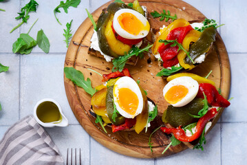 Bruschetta with cream cheese, baked bell peppers, arugula and soft-boiled egg..selective focus