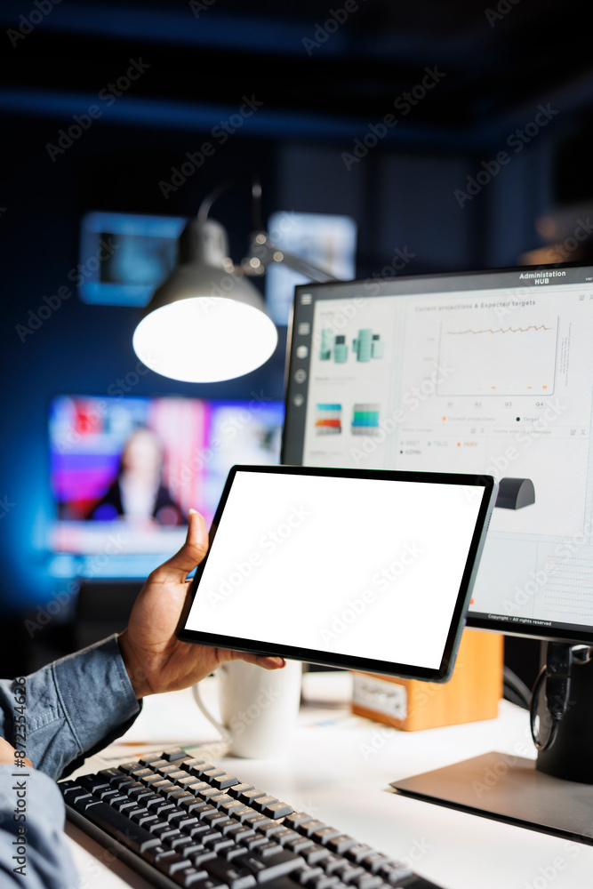 Poster young employee checks tablet with white screen at home, calculating finances and sales trend on comp
